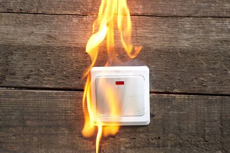 tongues of flame from wall socket, smoke fire occurred. Danger to life and healthの写真素材