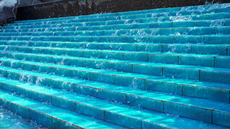 Unusual modern fountain design. Water flows cascade down the blue ceramic ladder steps in fountain...