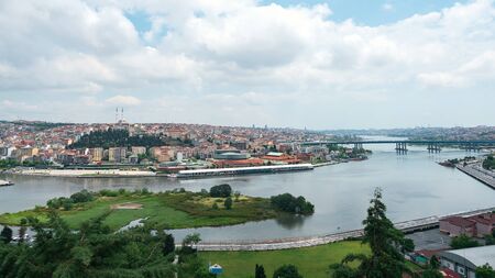 impressive panoramic view of bay with waterfront against cultural capital with skyscrapers under cloudy skyの写真素材