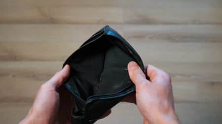 male hands open empty black wallet close up