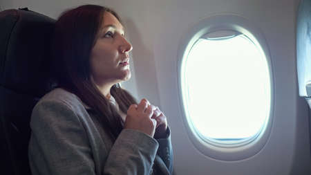 Young woman is very afraid of flying on an airplane.の写真素材