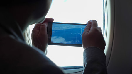 unrecognizable woman shoots a video of beautiful clouds from a porthole on phone.