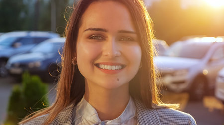 young woman with beautiful teeth smiling at camera, sunlight.