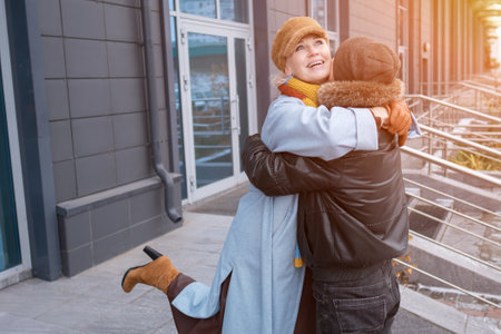 Elderly mother and daughter hugging happily in the city, enjoying a tender moment togetherの写真素材