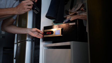 Criminal carefully unlocking hotel safe during nighttime, using flashlight while secretly accessing...