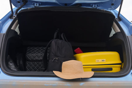 Yellow Suitcase And Backpack Inside Trunk With Straw Hat Nearby, Organized Packing Visible, Car...