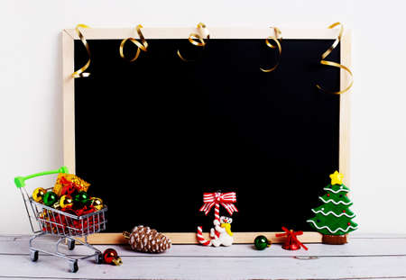 On a light background, a black note board, a cart with gifts, Christmas decor. Copy space. Christmas conceptの写真素材