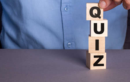 The word QUIZ is made by a man from wooden cubesの写真素材