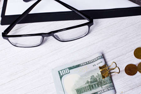 On a white table are money and black-framed glasses. Business concept close upの写真素材