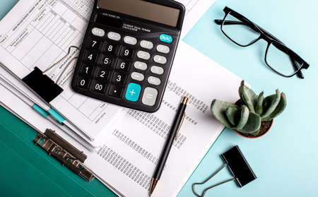 On a blue background are charts, calculator and other office stationeryの写真素材