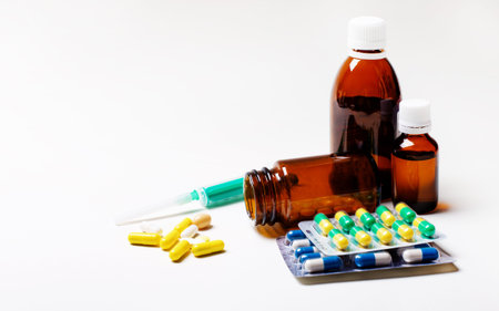 Different medical bottles and tablets isolated on white