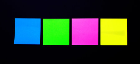 On a black background, bright self-adhesive stickers for notes. Place to insert text