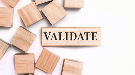 On a light background, wooden cubes and a wooden block with the text VALIDATE. View from aboveの写真素材