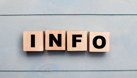Wooden cubes with the text INFO on a light blue wooden background.の写真素材