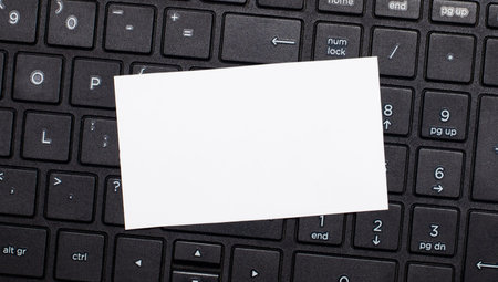 The computer keyboard has a white blank card for inserting text. Template. Top view with copy space
