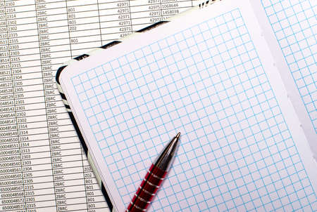 There are reports on the desktop. They have an open, blank notebook and a pen on them. Template. Place to insert textの写真素材