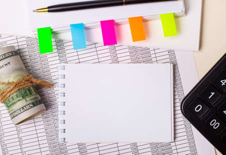 On the desktop there are reports, notepads, calculator, pen, cash and notepad with colorful stickers and place to insert text. Templateの写真素材