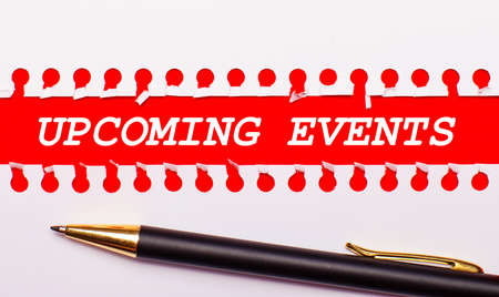 Pen and white torn paper strip on a bright red background with the text UPCOMING EVENTSの写真素材