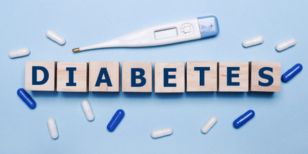 On a light blue background, an electronic thermometer, white and blue pills and wooden cubes with...