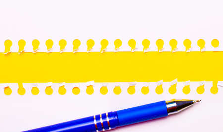 Blue pen and white torn paper strips on a bright yellow background with copy space for text or illustration. Templateの写真素材