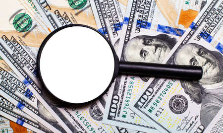 Background with American dollar bills under a magnifying glass. Place to insert text. Focus on America's politics and economics.の写真素材