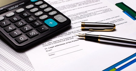 On the desktop there are reports, a calculator and a fountain pen. Workplace close-up. Business...