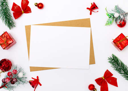 Over white background Christmas decor around a blank sheet of paper with place to insert text on a red background. Festive concept. Flat lay with a place to insert text. New Year cardの写真素材