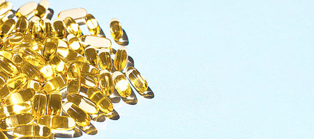 Omega-3 capsules lie on a light blue background. Fish oil tablets. Health support and treatment....
