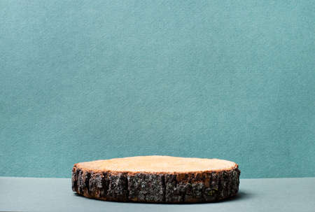 Wooden podium on a green background for a cosmetic product mockup. Round wooden cylinder shape for product presentation on a green background. A piece of woodの写真素材