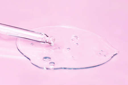 Cosmetic oil, acid or serum and pipette on a pink background.の写真素材