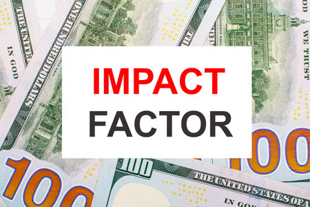 Against the background of American dollars, a white card with the IMPACT FACTOR. financial concept
