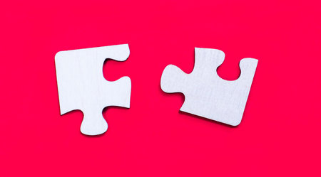 Wooden figures with puzzles on red background. Agreement between business men, cooperation and deal...