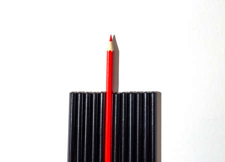 The red pencil stands out from the crowd of black pencils on a light background. leadership conceptの写真素材