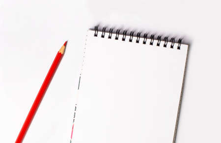 Red pencil and blank notepad with space to insert text on a light background. copy spaceの写真素材