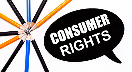 On a light background, multi-colored pencils and on a black background a white card with the text CONSUMER RIGHTSの写真素材