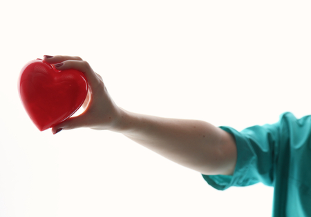 A doctor with stethoscope examining red heart .の写真素材