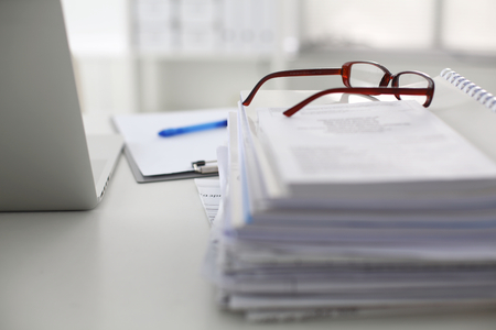office desk a stack of computer paper reports work forms.の写真素材