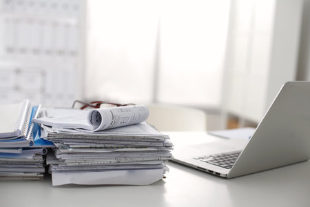 office desk a stack of computer paper reports work forms.