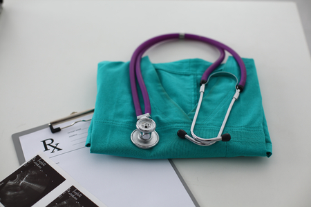 Doctor clothes lying on the table with a stethoscope.の写真素材