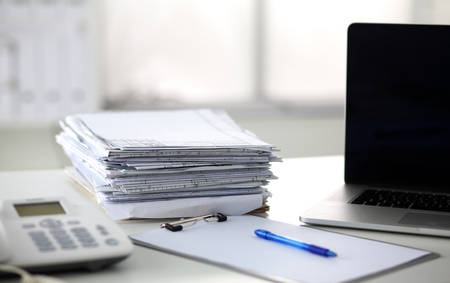 office desk a stack of computer paper reports work forms.の写真素材