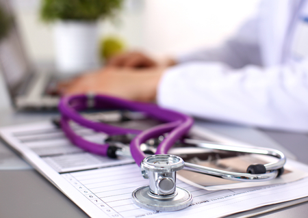 Portrait of young woman doctor in white coat at computer.の写真素材