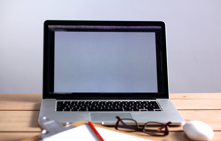 Laptop stands on a wooden table .の写真素材