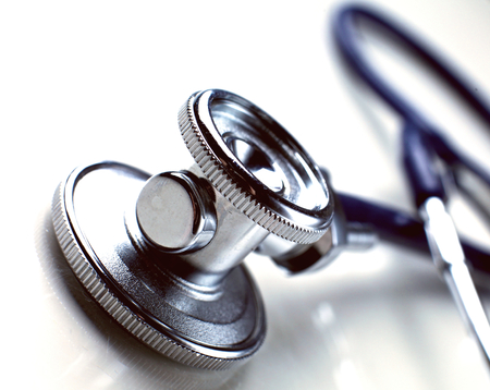 Medical violet  stethoscope lying in white backgroundの写真素材