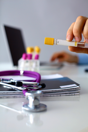 Doctor at work, close up of male doctor typing on a laptop.の写真素材