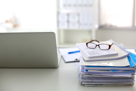 Stack of papers and glasses lying on table desaturated.の写真素材