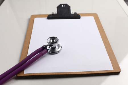 Medical stethoscope and a plate on the table.の写真素材