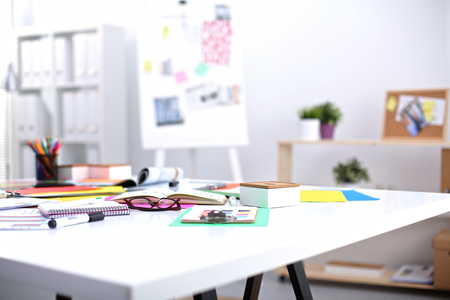 Desk of an artist with lots of stationery objects. Studio shot on wooden background.