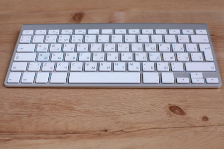 computer keyboard lying on a wooden table.の写真素材