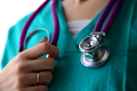 Close-up of unknown female doctor with stethoscope isolated.