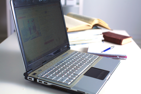 Office table with blank notepad and laptop .の写真素材